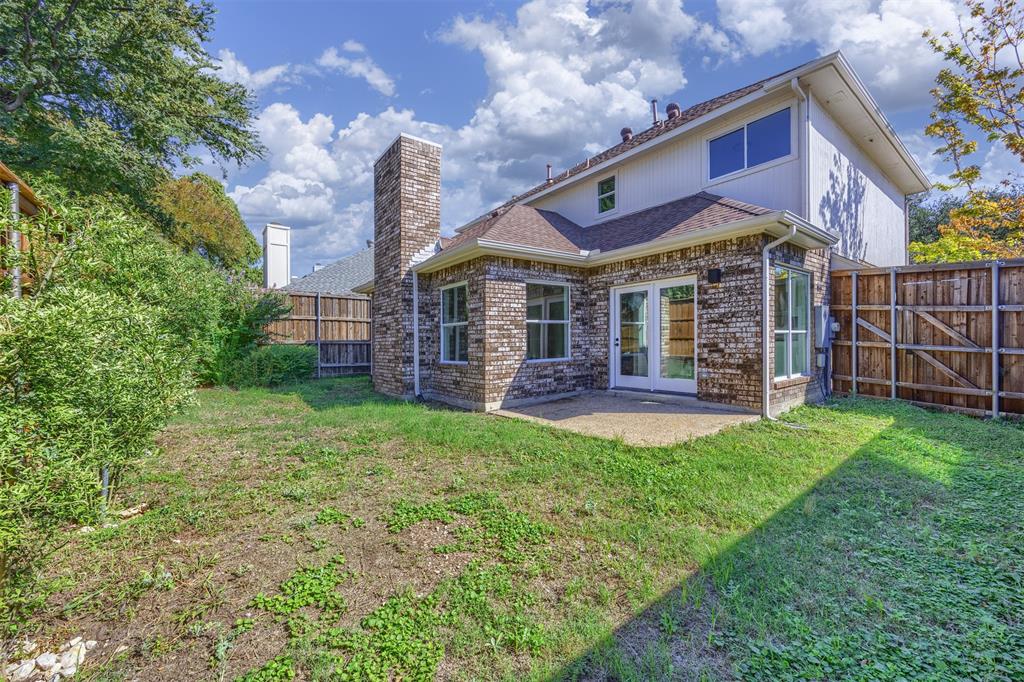 Rear photograph of home showing the patio door, patio and yard.  There is a natural gas line hookup on the patio for a gas grill.
