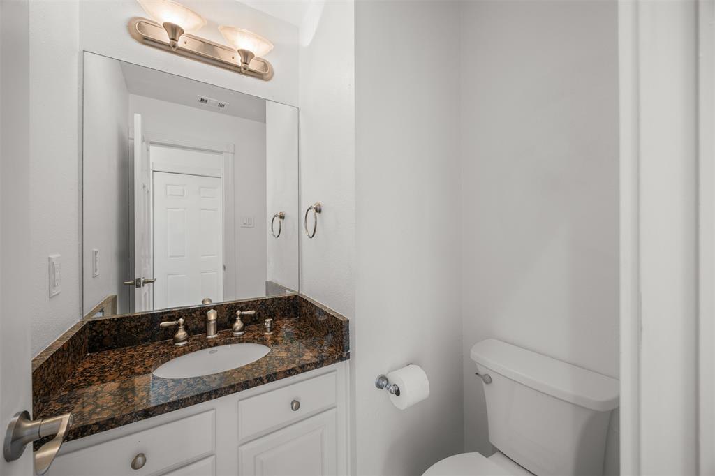 First floor half bath with granite countertop, brushed nickel faucet, soft close cabinet doors and new Kohler toilet.  Floor is Travertine.  All doors are solid wood, six panel with new brushed nickel latches and hinges installed.  These same finishes are in place throughout the home.