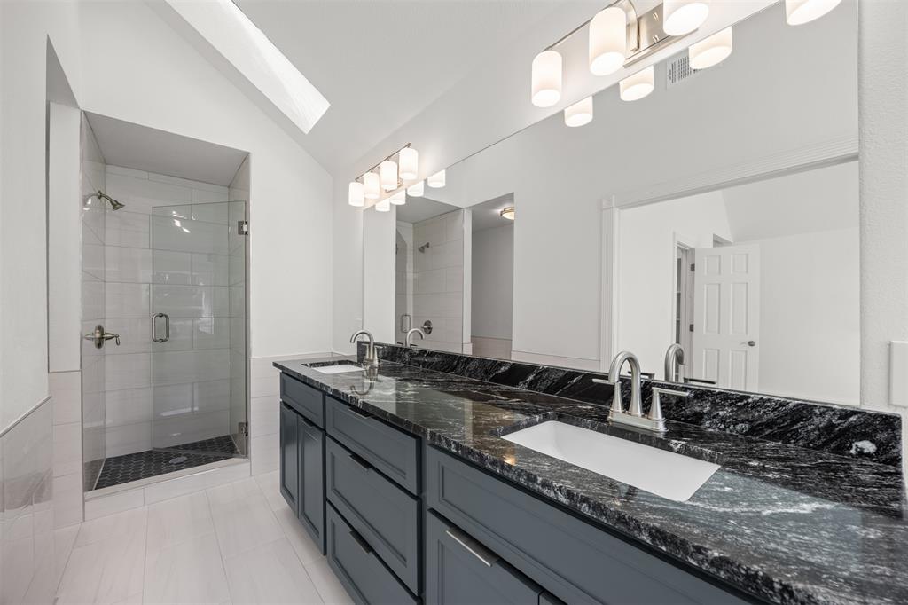 Master Bath showing custom vanity, soft closing drawers and doors, granite countertop, new rectangular undermount sinks, new brushed nickel faucets, mirror and lighting.  The new shower enclosure includes brushed nickel controls and a frameless glass shower door.