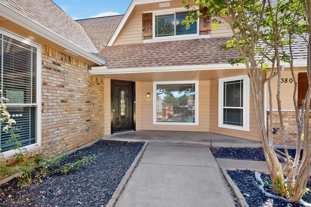 Brick and siding exterior with a concrete walkway, covered entryway, and integrated landscaping Brick and siding exterior with a concrete walkway, covered entryway, and integrated landscaping