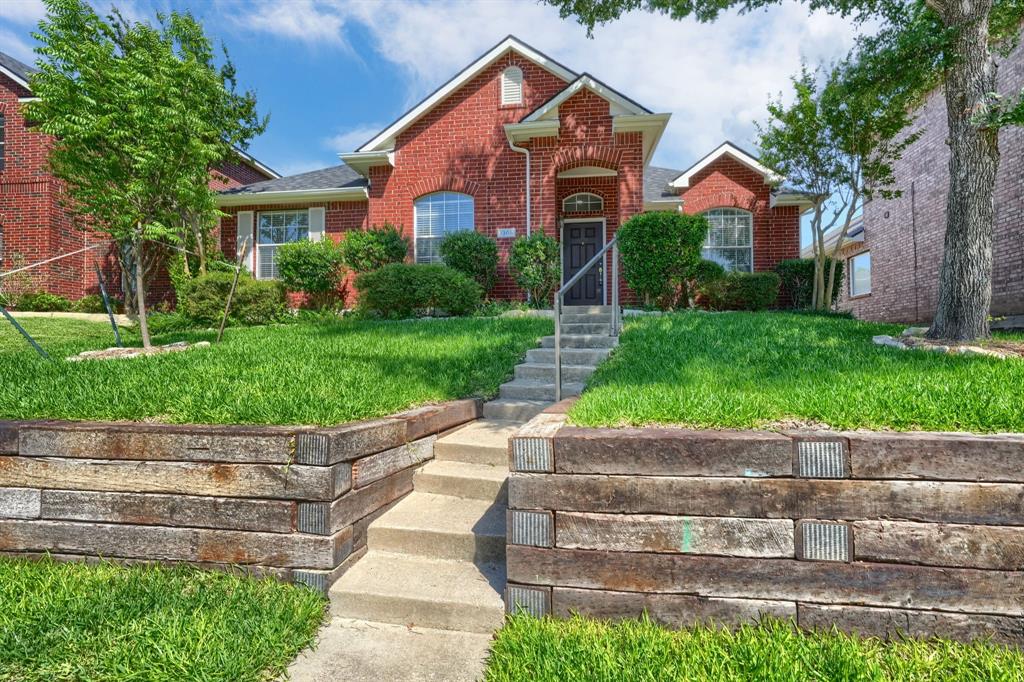 Red brick exterior with white window trim and a dark entry door