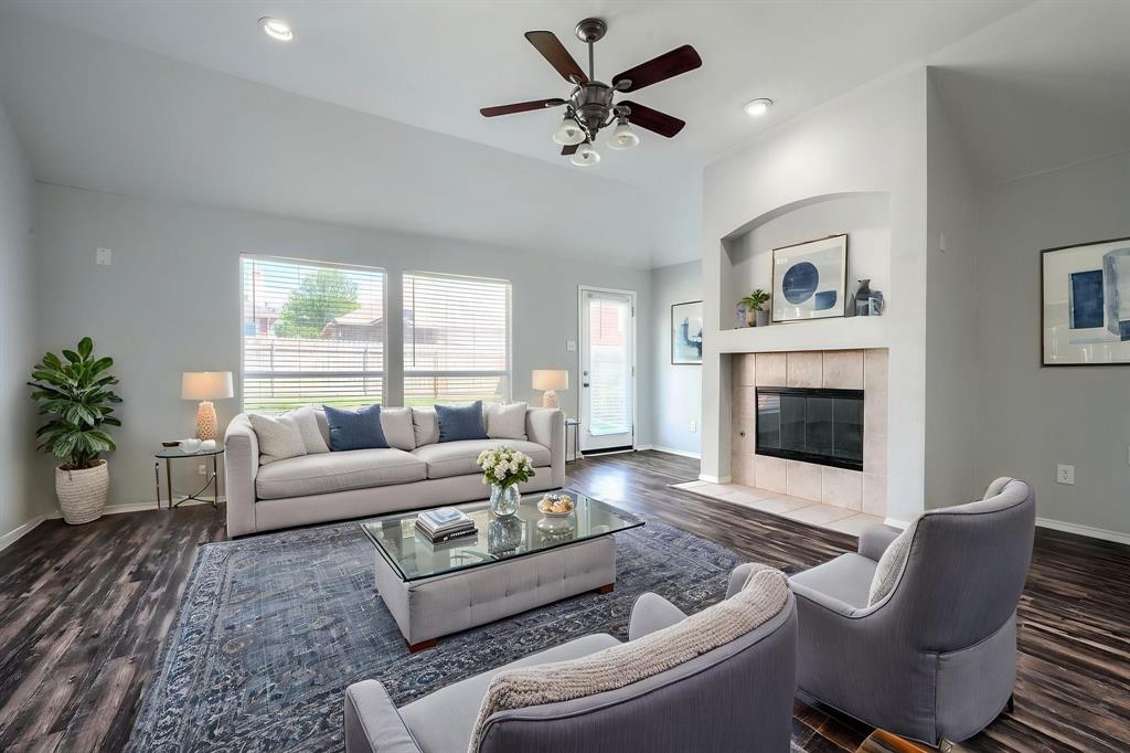 Vaulted ceiling with a ceiling fan, recessed lighting, wood-finish flooring, and a fireplace with a tile surround and hearth