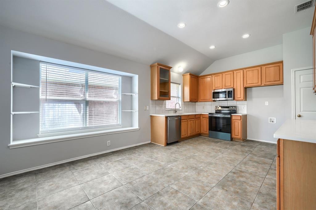 Kitchen featuring wood cabinetry, stainless steel appliances, white countertops, tile flooring, and recessed lighting