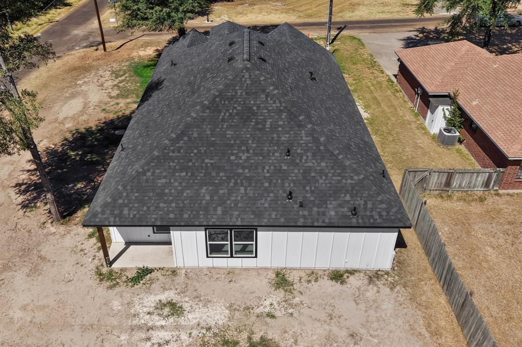 Pitched shingle roof, white vertical siding, and black-framed windows