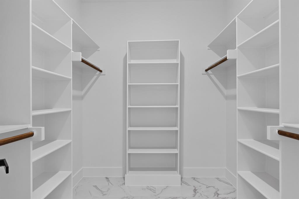 Custom closet system featuring extensive shelving, central built-in storage, and integrated hanging rods
