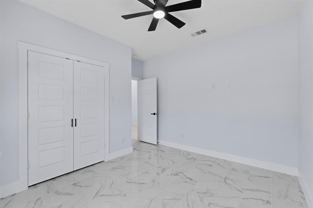 White walls with sleek white trim, a black ceiling fan, and white doors with matte black hardware