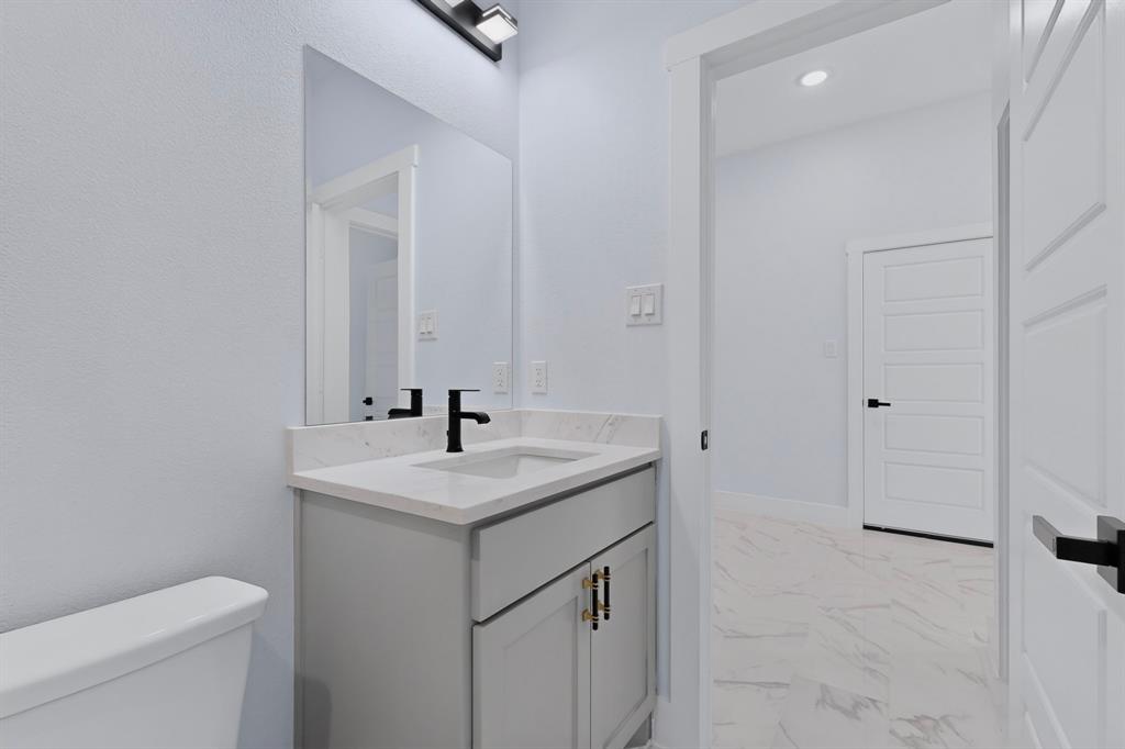 Bathroom featuring a modern vanity with light gray cabinetry, white countertop, and matte black faucet