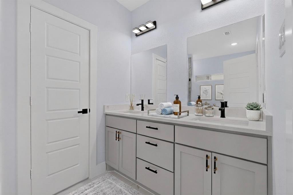 Dual vanity with light gray cabinetry, matte black hardware, and two integrated rectangular sinks