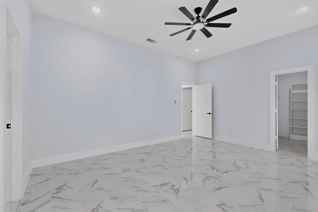 Recessed lighting, ceiling fan with black blades, and marble-finish flooring