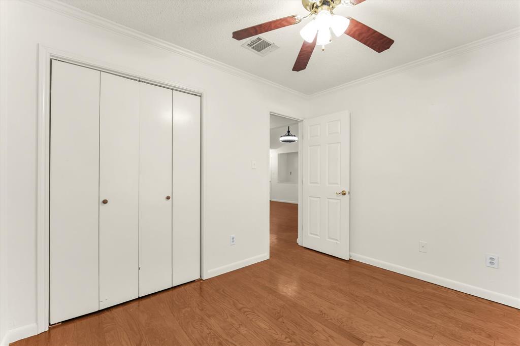 Hardwood-style flooring throughout with a ceiling fan light fixture and bi-fold closet doors