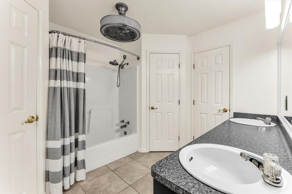 Dual vanity with undermount sinks, speckled countertop, and chrome fixtures