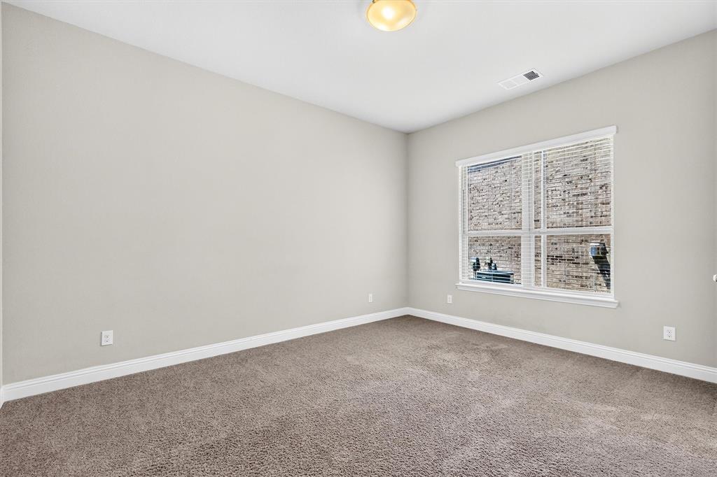 Neutral painted walls, wall-to-wall carpeting, and a window with blinds