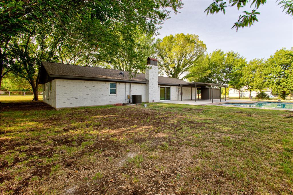 White Brick Exterior wDark Shingled Roof & Pronounced Chimney.
