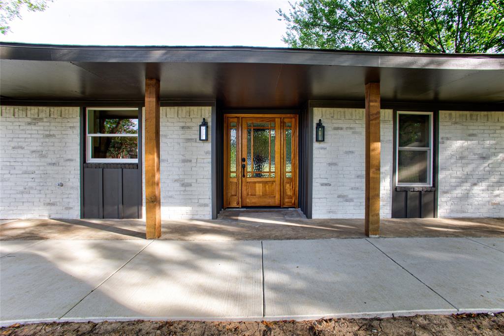 New Grand Solid Wood Front Door wTwo Side Lights & Exterior Wood Stained Accents To Match. And Wide Concrete Wrap Sidewalk Fr Carport
