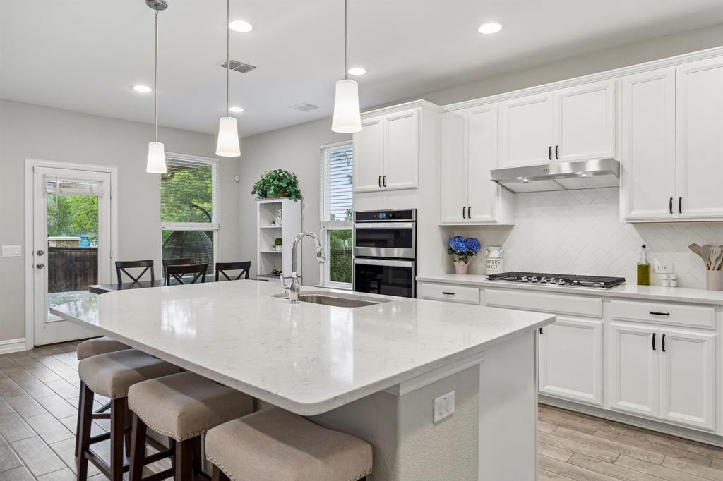 Clean and crisp transitional decor with a huge island for culinary preparation