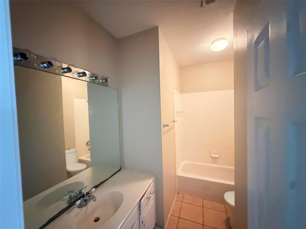 Vanity with integrated sink, chrome faucet, and overhead lighting