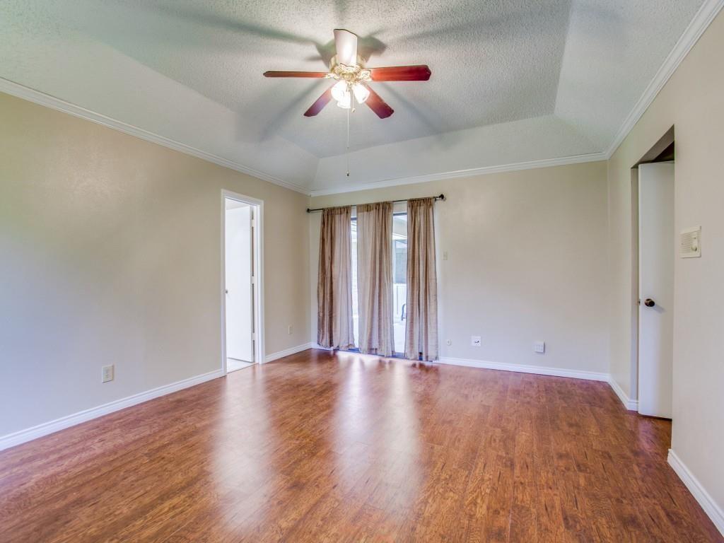 Tray ceiling with a ceiling fan, wood-finish flooring, and white trim