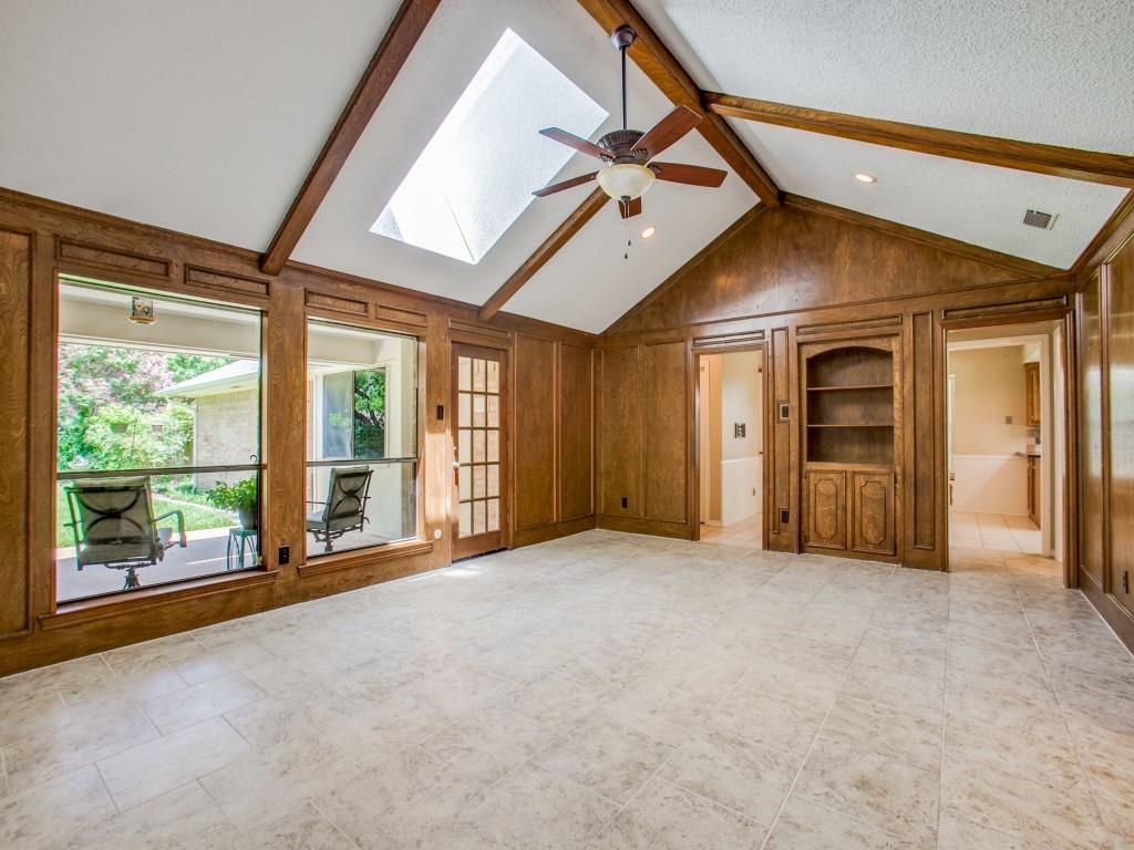 Vaulted ceiling with exposed wood beams, skylight, and ceiling fan