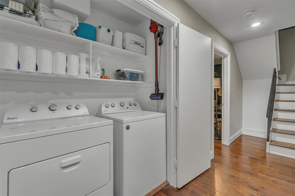 Laundry area with a full-size washer and dryer, built-in shelving.