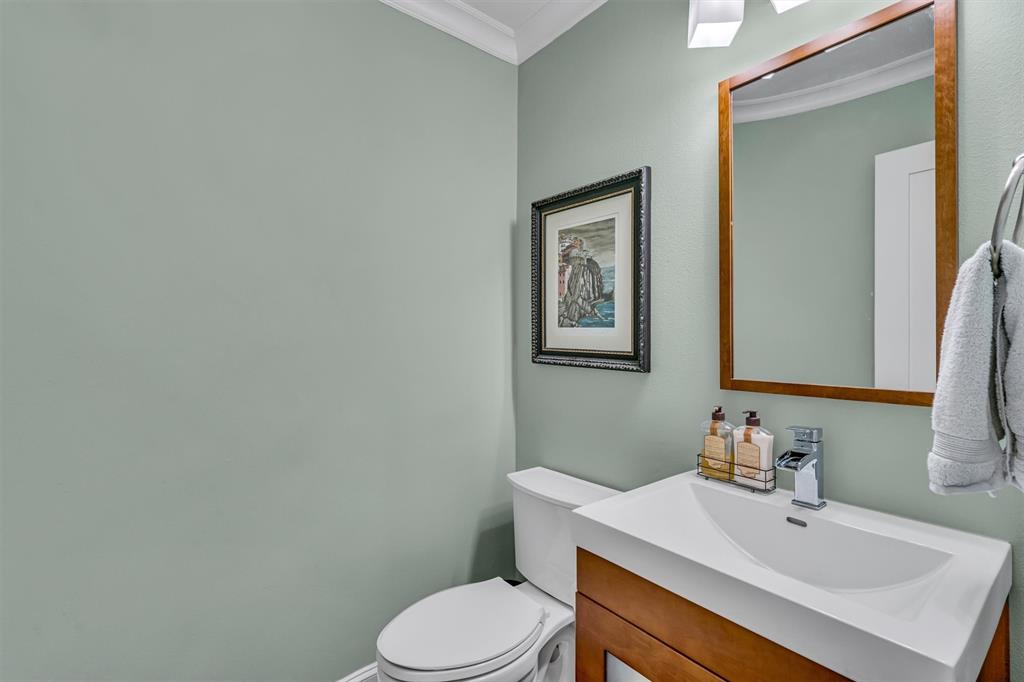 Modern vanity with an integrated sink, polished chrome faucet, wood-finish cabinetry, and a framed mirror
