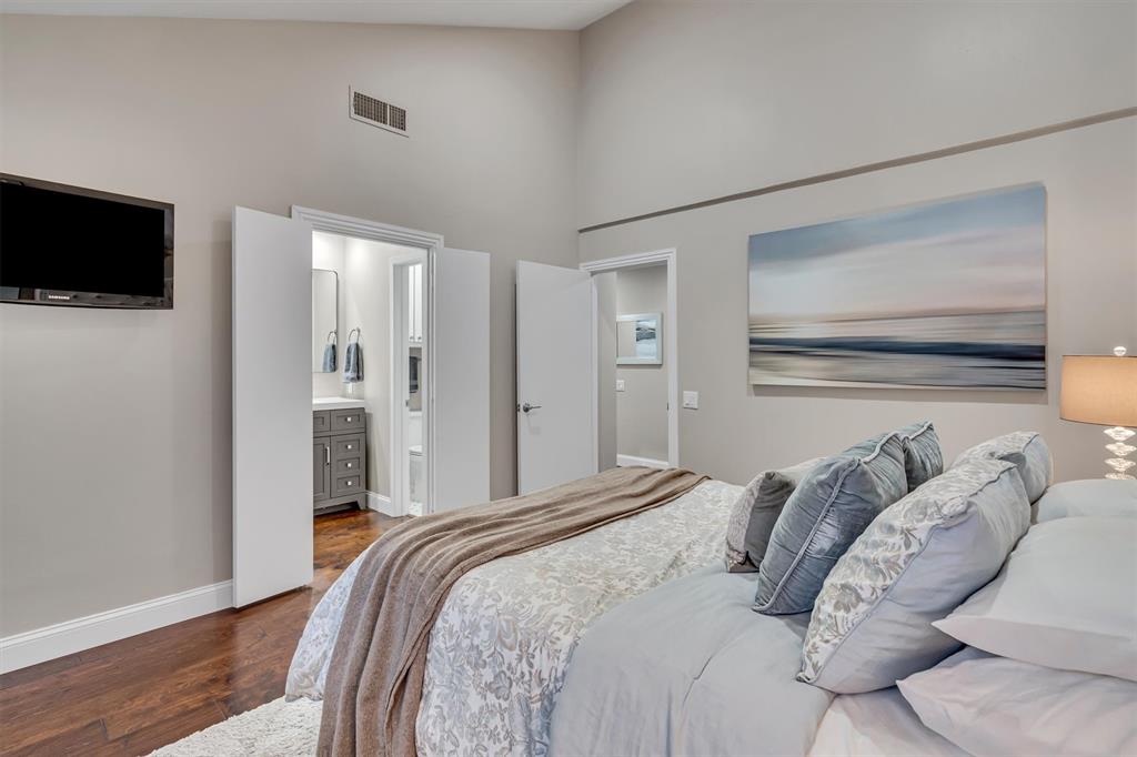 Vaulted ceilings with recessed lighting, wood-finish flooring, and en-suite bathroom.