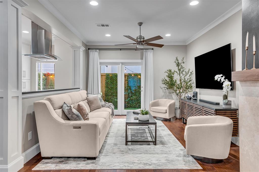 Recessed lighting illuminates wood-finish flooring, a ceiling fan, and crown molding