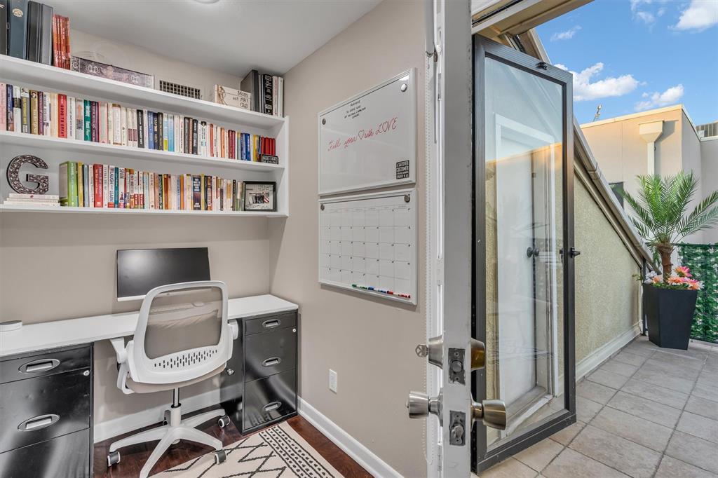 Built-in wall shelving, wood-finish flooring, and direct access to an outdoor roof-top patio and storage room.