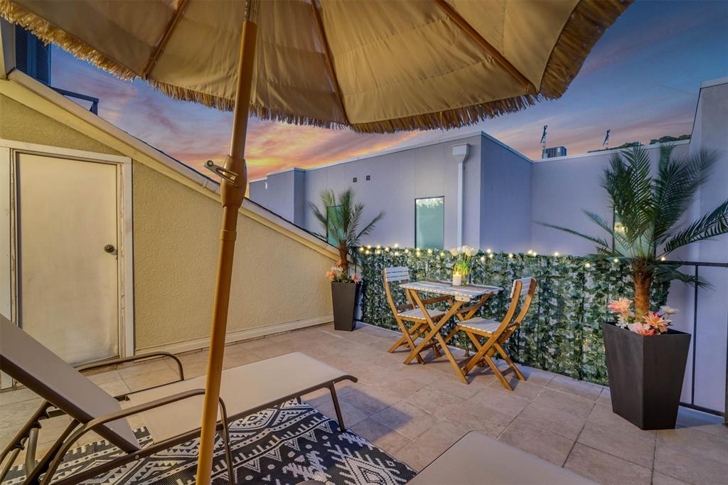 Tiled outdoor rooftop patio featuring a privacy wall, storage room, integrated lighting, and perimeter railing