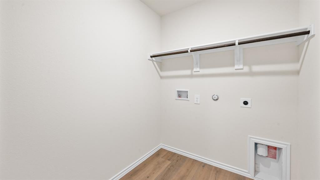 Wood-finish flooring, overhead shelving, and a hanging rod
