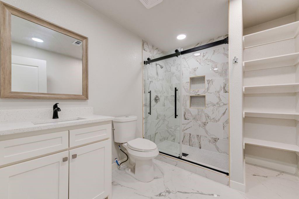 White vanity with a quartz countertop and integrated sink