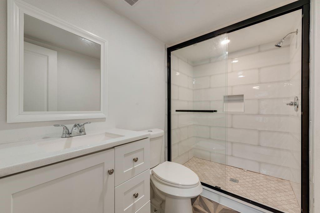White shaker vanity with integrated sink, chrome faucet, and framed mirror