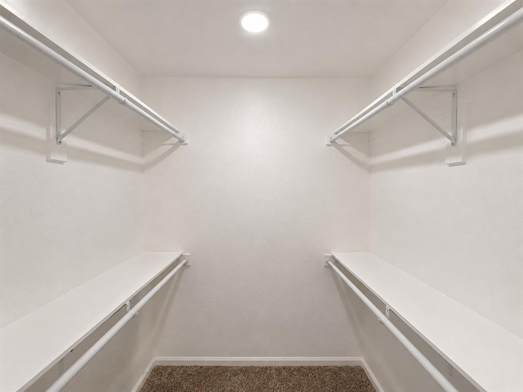Built-in storage shelves and hanging rods, recessed ceiling lighting, and textured wall finishes