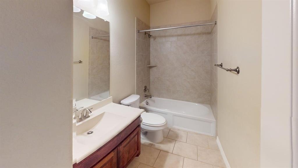 Vanity with wood-finish cabinetry, integrated sink, and dual-handle faucet