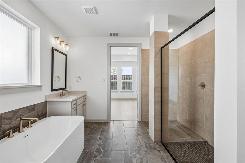 This dream owner's bath offers ample room for two with dual vanities and a luxurious free standing tub!