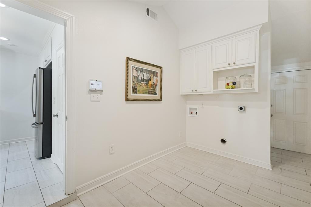 The generously sized laundry room provides space for an exercise bike or a yoga mat if multitasking is your thing. The door to the right leads to the backyard deck.