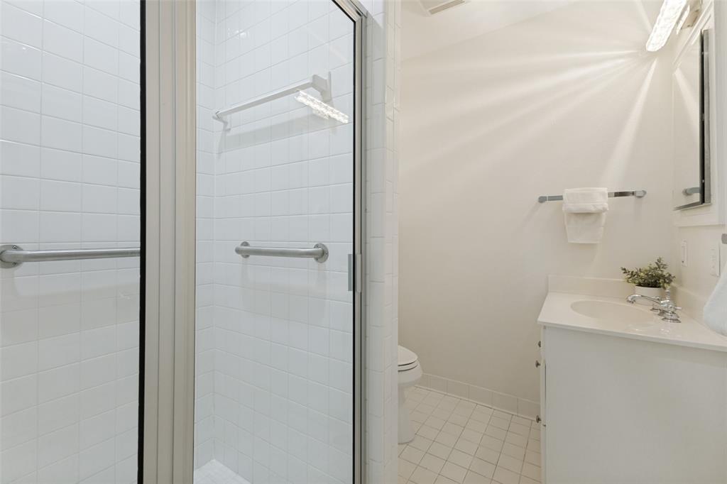 A walk-in shower is featured in this hall bath, conveniently located near the kitchen and secondary bedrooms.