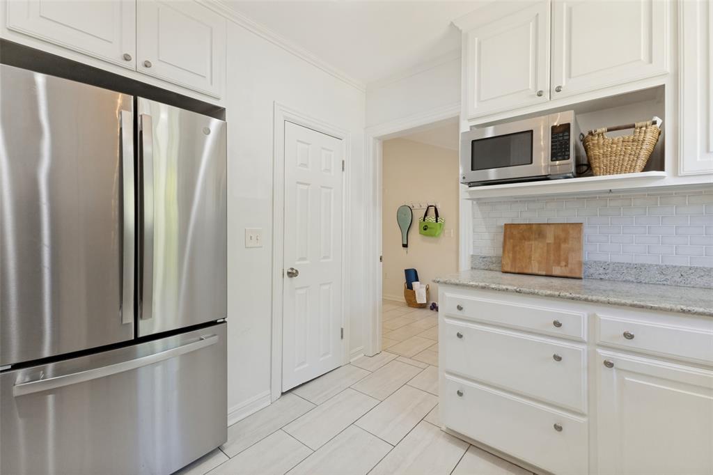 Walk-in pantry to the right of the refrigerator/freezer, and the laundry room and garage just beyond.