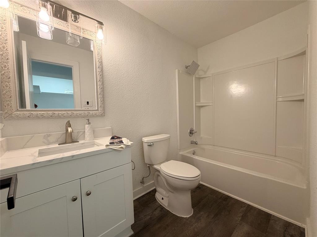 Vanity with a quartz countertop, integrated sink, and brushed nickel faucet