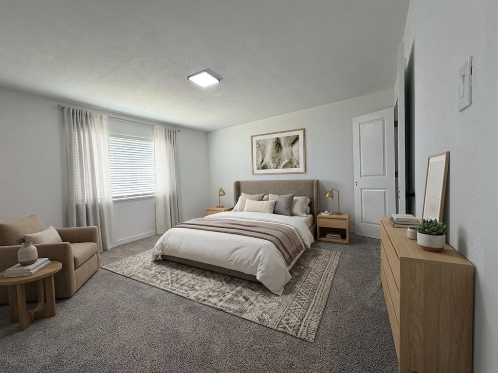 Staged- Wall-to-wall carpeting with a neutral finish, light-colored walls, and a window with blinds and sheer curtains
