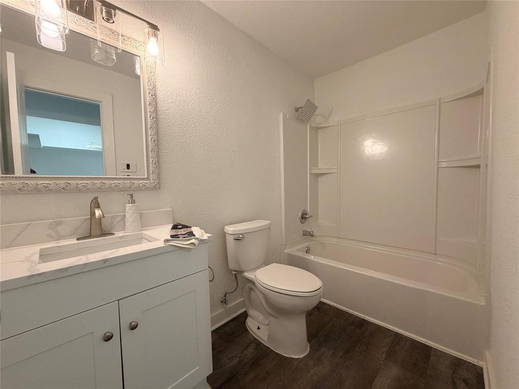 White vanity with a rectangular integrated sink, brushed nickel faucet, and decorative mirror