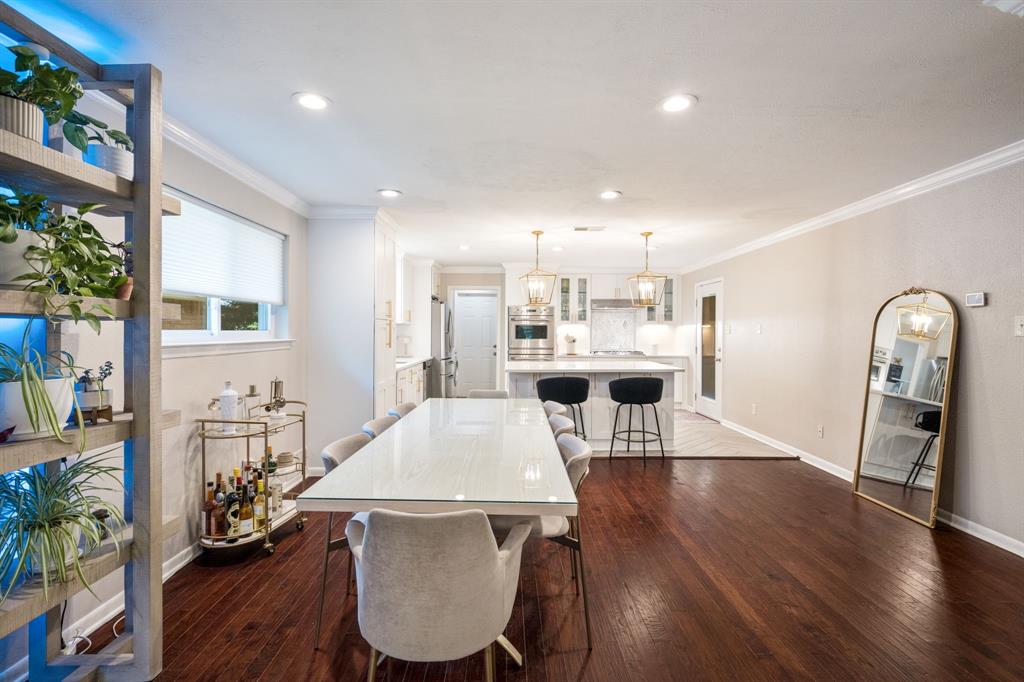Open-concept living area with dark wood-finish flooring, recessed lighting, and crown molding