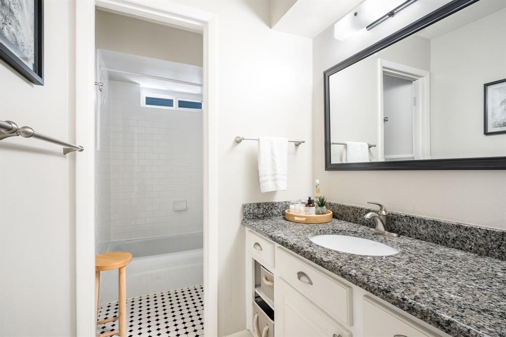 Vanity with a granite countertop, undermount sink, and brushed nickel faucet