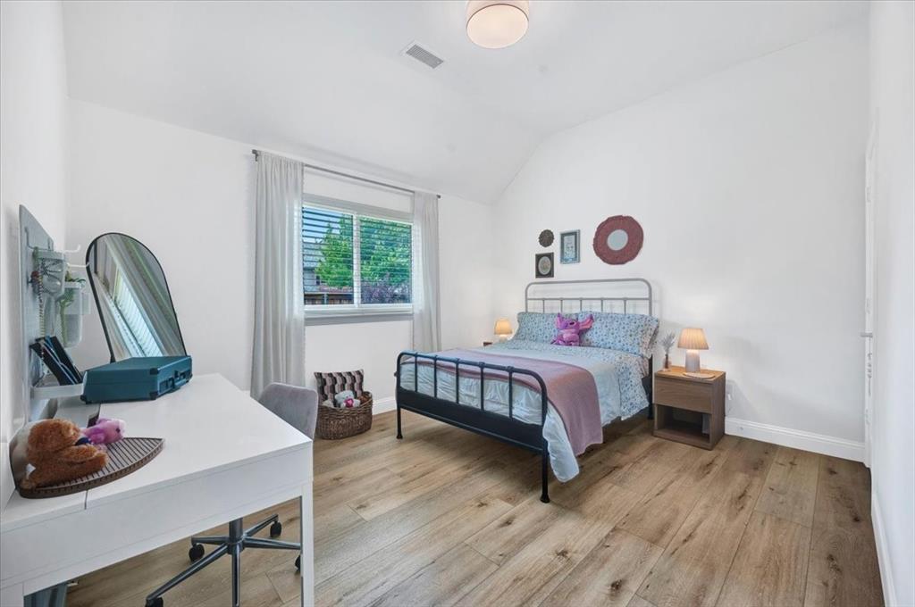 Vaulted ceiling, recessed lighting, wood-finish flooring, and a window with blinds
