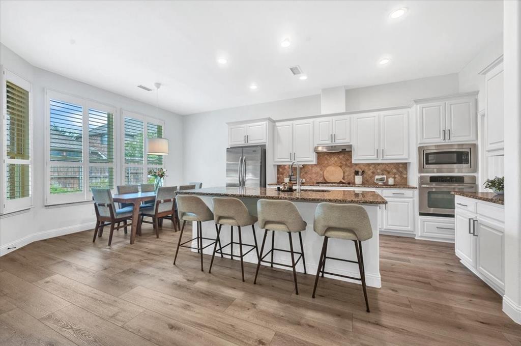 Bright kitchen with white cabinetry and stainless steel appliances