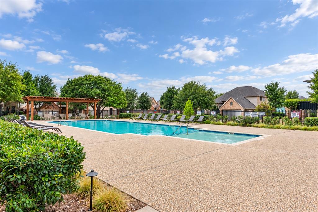 Large outdoor swimming pool with surrounding aggregate concrete decking