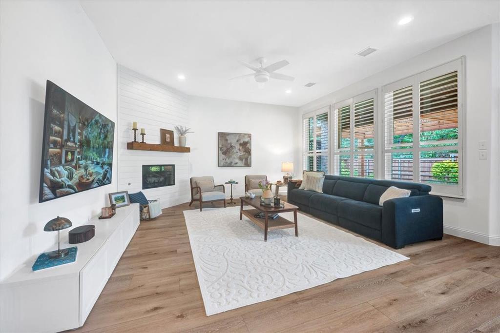 Wide plank wood-finish flooring, recessed lighting, and a ceiling fan