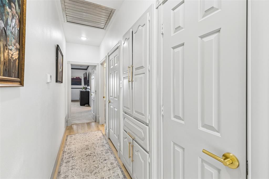 Hallway with wood-finish flooring, recessed lighting, and built-in cabinetry