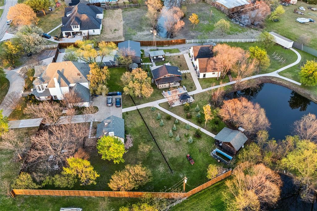 Manicured grounds featuring a private pond, extensive pathways, and multiple dwellings
