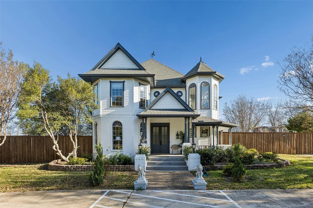 Victorian-style exterior with a turret, covered porch, multiple gables, and a fenced yard