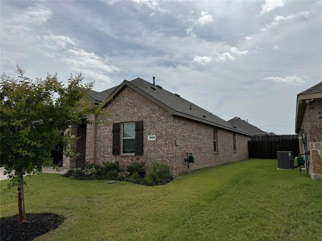Brick exterior with dark shutters, gabled roofline, and attached fencing Brick exterior with dark shutters, gabled roofline, and attached fencing